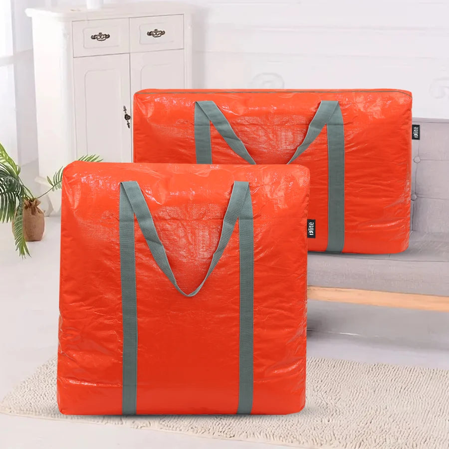 Two bright orange collapsible storage bags with gray handles, displayed in a clean indoor setting with a white cabinet and plant in the background.